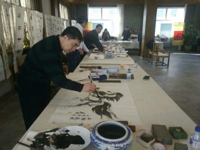 刘建国生活-朝阳区文联举行书画进社区新年笔会,人气颇旺，刘建国现场作国画《奔马》一幅。【图3】